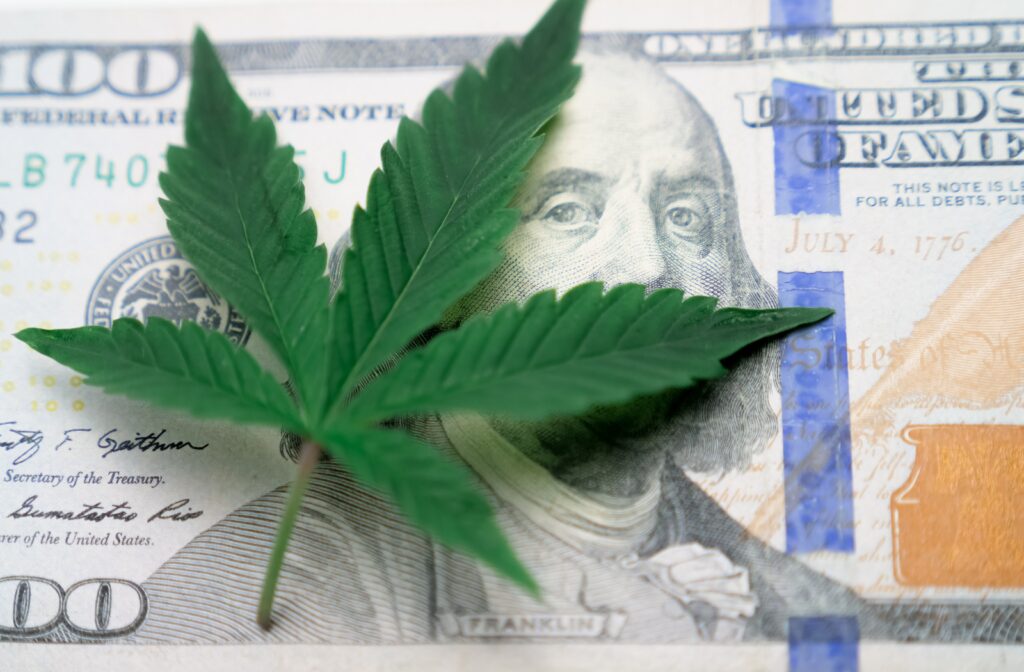 Cannabis leaf on a one hundred dollar bill representing cannabis business revenue, cash flow, and financial compliance.